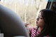 A woman sitting in a car looking out the window.