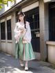 A woman in a pink and green kimono is walking down the street.