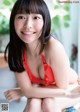 A woman in a red bikini sitting on a chair.