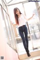 A woman standing in front of a glass door.