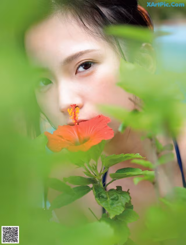 A woman with a flower in her mouth. 