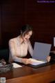 A woman sitting at a desk with a laptop computer.