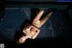 A woman in a bikini laying on a metal floor.