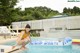 A woman in a yellow bikini sitting on an inflatable pool float.