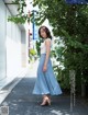 A woman in a blue skirt is walking down the street.