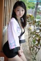 A woman in a pink and black kimono posing for a picture.