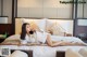 A woman laying on a bed in a hotel room.