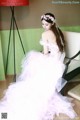 A woman in a wedding dress sitting on a chair.