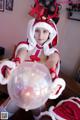 A woman dressed as a santa claus holding a crystal ball.