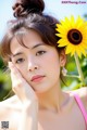 A woman with a sunflower in her hair. 