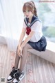 A woman in a school uniform sitting on a window sill.