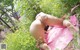 A woman laying on a pink towel in the grass.