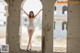 A woman in a white dress standing in an abandoned building.