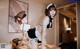 A woman in a maid outfit posing on a desk.