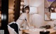 A woman in a maid outfit cleaning a desk.