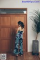 A woman standing in front of a wooden door.