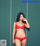 A woman in a red bra and panties posing for a picture.