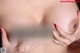 A close up of a woman's breasts with red fingernails.