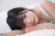 A young woman laying on a bed with her head on the pillow.