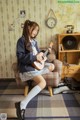 A woman sitting on a chair playing a ukulele.