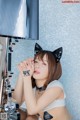 A woman wearing a cat ears headband sitting in front of a mirror.