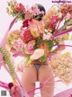 A woman in a thong holding a bunch of flowers.